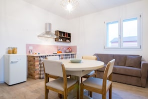 A compact kitchen with a dining area, a built-in oven, and a window with a view. - Farmhouse in Marche with Pool near Adriatic Sea (Fermo)