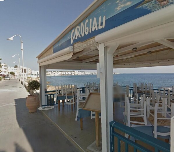 Un restaurante frente al mar llamado "CARROGIALI" con terraza y vistas al océano.