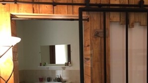Une salle de bain avec un lavabo blanc, un miroir et un sol carrelé.