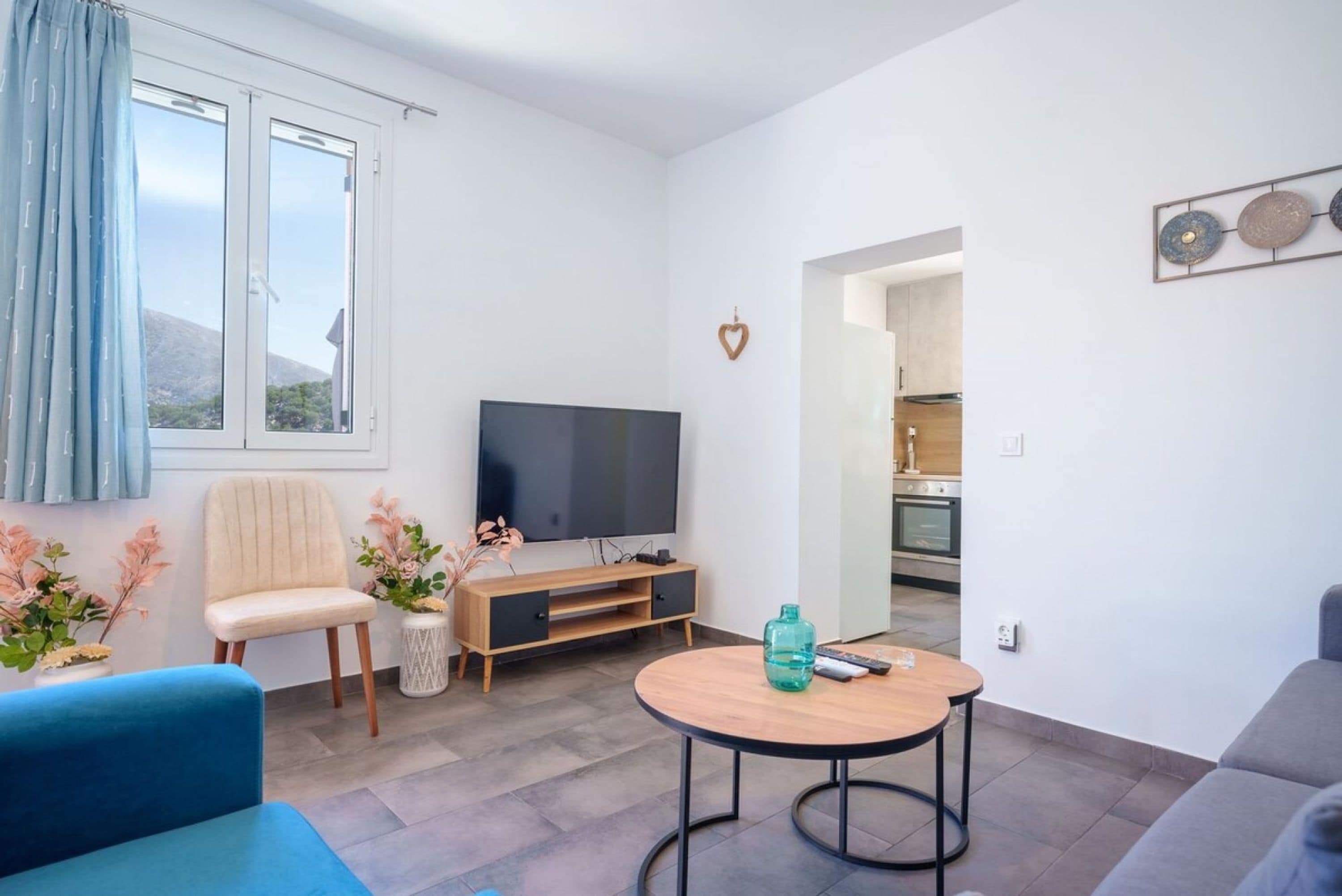 A modern living room with a TV, sofa, and a small table.