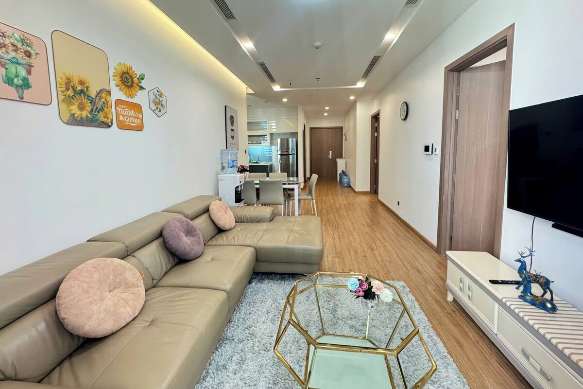 A modern living room with a sectional sofa, a coffee table, and a TV.
