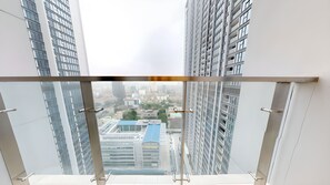 A high-rise building with a view of a cityscape, including a blue-roofed building and other structures. - Luxury Apartment Metropolis NNP (Hanoi)