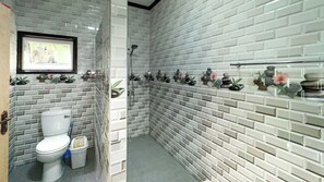 A bathroom with a toilet, a shower, and a sink. - LA VILLA HORTENSIA (La Digue)
