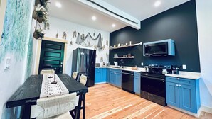 Eine moderne Küche mit blauen Schränken, einem Edelstahlkühlschrank und einer Mikrowelle.
