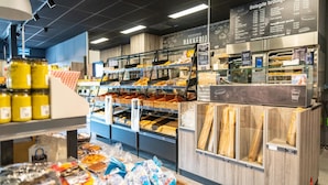 A bakery section with various baked goods and a menu board listing items. - Villa by Lake Veere With Sauna (Wolphaartsdijk)