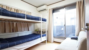 Un dormitorio con literas, un escritorio y una ventana con cortinas.