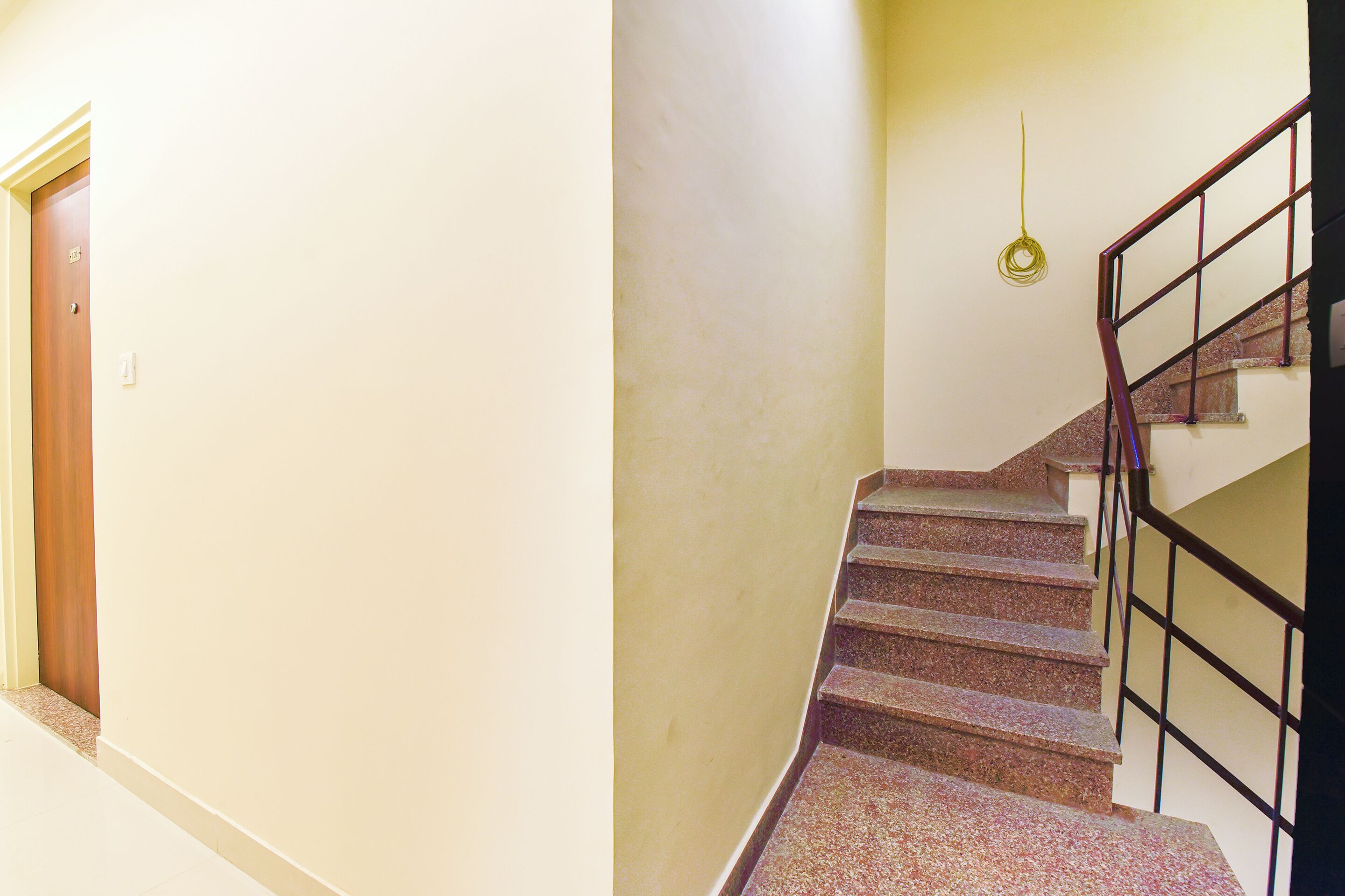 Un escalier avec une rampe et une porte en haut.