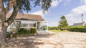 A two-story house with a stone facade, a tiled roof, and a front porch. - Charming house with south-facing veranda and pets allowed (Le Vast)