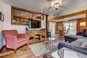 Relax in this inviting living room with a comfortable armchair, plush sofa, and entertainment center featuring a flat-screen TV.
