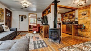 Ein gemütliches Wohnzimmer mit Kamin, Sofa, Couchtisch und Teppich.