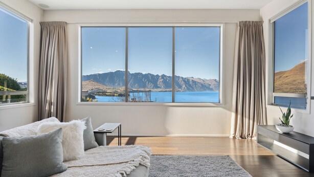 A modern living room with a large window offering a scenic mountain view. - Luxury Retreat - Matakauri (Queenstown)