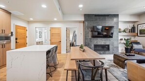A modern kitchen with a marble island, wooden cabinets, and a built-in microwave. - Bluebird Bunkhouse|Includes Two 1-Day Lift Tickets (Tamarack)
