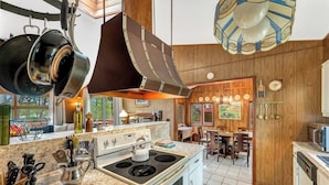 A modern kitchen with granite countertops, stainless steel appliances, and wooden paneling.