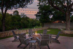 Een terras met Adirondack-stoelen en een vuurkuil.