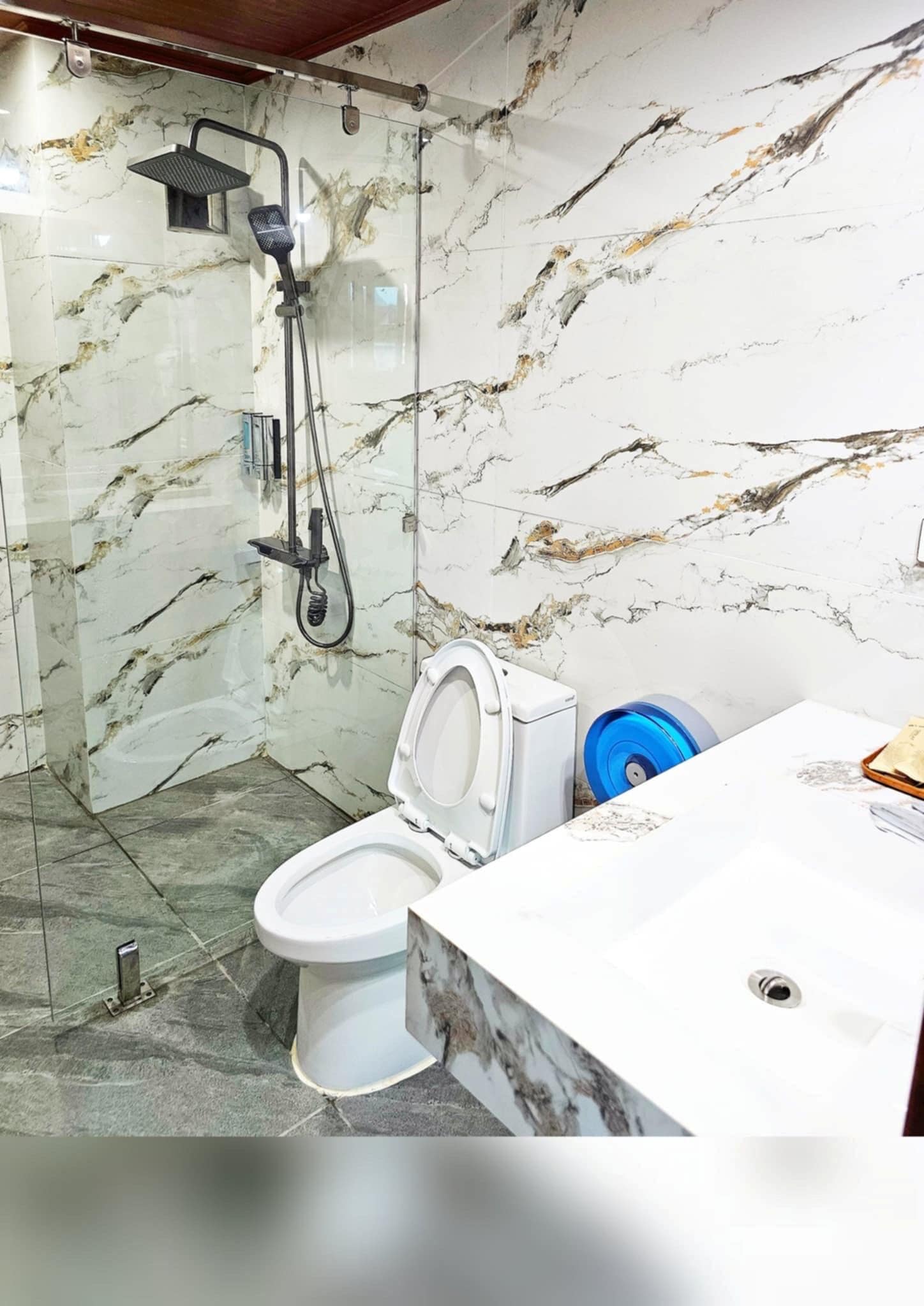 A bathroom with a shower, toilet, and sink.
