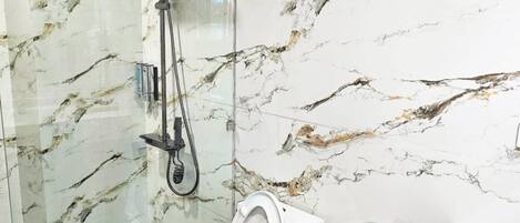 Ein Badezimmer mit Dusche, Toilette und Waschbecken.