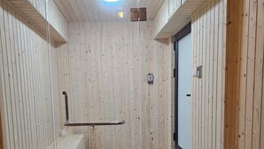 Un sauna aux murs en bois et au sol carrelé.