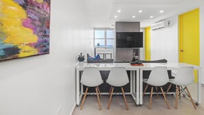 A modern kitchen with a white countertop, grey cabinets, and a yellow door. - Yellow Luxury PH | Steps from the beach in Condado (San Juan)