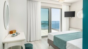 Ein Hotelzimmer mit Bett, Schreibtisch, Fernseher und Meerblick.