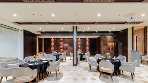 A modern dining area with hexagonal patterned flooring, round tables, and contemporary chairs. - Signature Hotel (Ajmer)