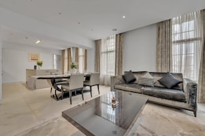 A modern living room with a sofa, coffee table, and dining area.