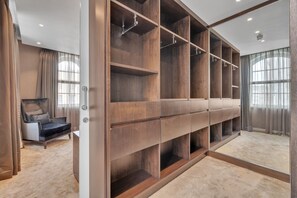 A walk-in closet with multiple wooden shelves and a mirrored closet door. - 2B Flat with lift and AC in Baker St (Greater London)