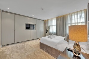 A modern hotel room with a large bed, a bedside table with a lamp, a wardrobe, and a large window with curtains. - Beautiful apartment with lift in Baker St (Greater London)