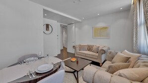 A modern living room with a dining area, a beige sofa, and a coffee table. - Beautiful apartment with lift in Baker St (Greater London)