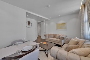 A modern living room with a dining area, a sofa, and a coffee table. - Beautiful apartment with lift in Baker St (Greater London)