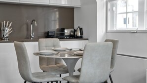 Una cocina moderna con comedor, que incluye una mesa redonda, cuatro sillas y un ventanal.