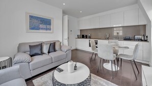 Una sala de estar moderna con un sofá, una mesa de centro y un comedor.