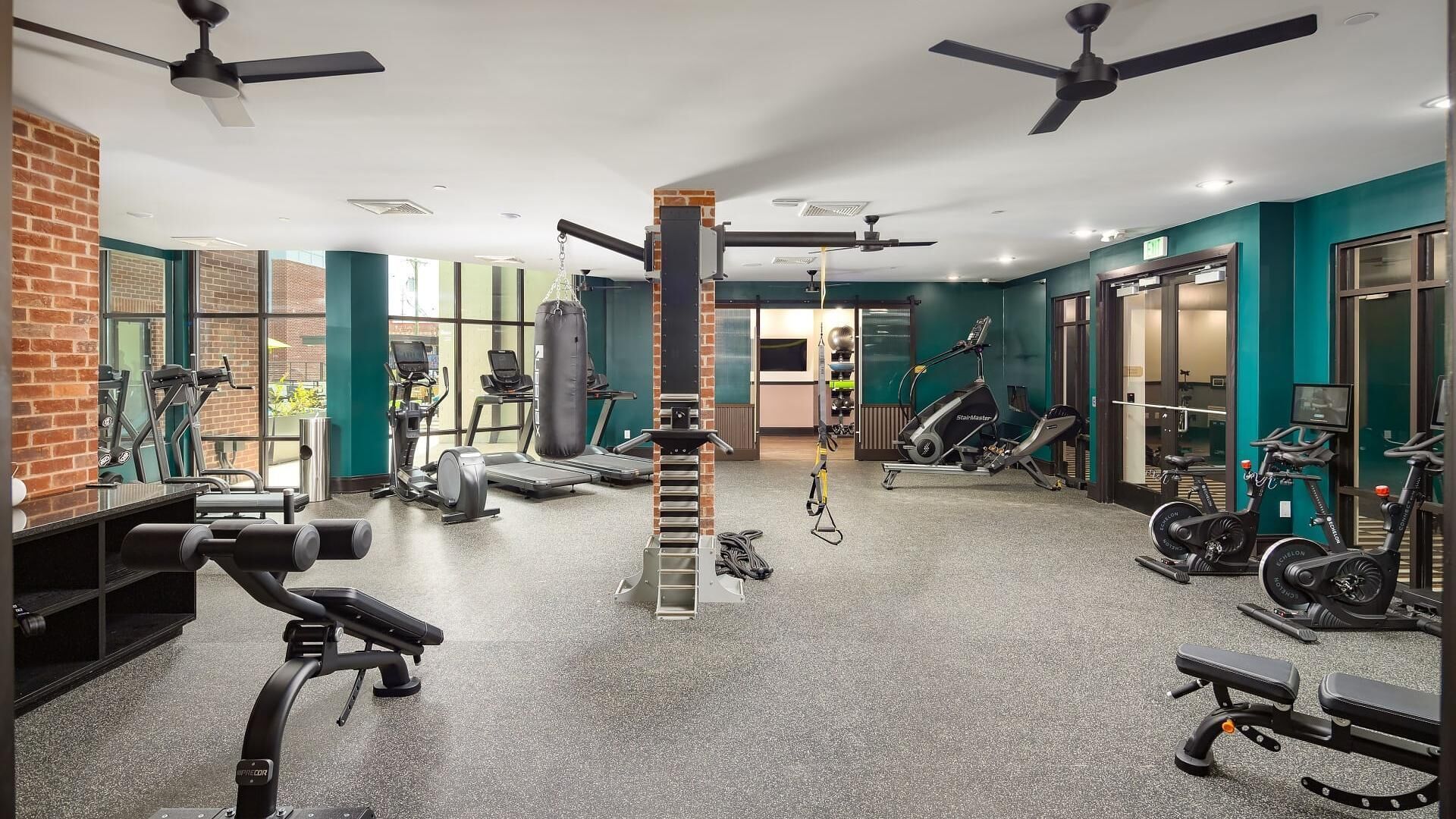 A gym with various exercise equipment, including treadmills, stationary bikes, and weight machines.