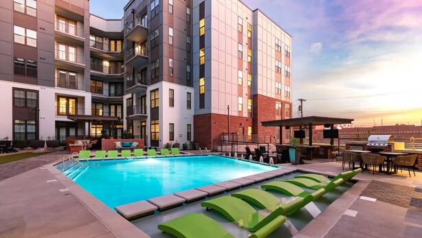 Un hôtel moderne doté d’une piscine sur le toit, d’un espace extérieur aménagé et d’une façade en briques.