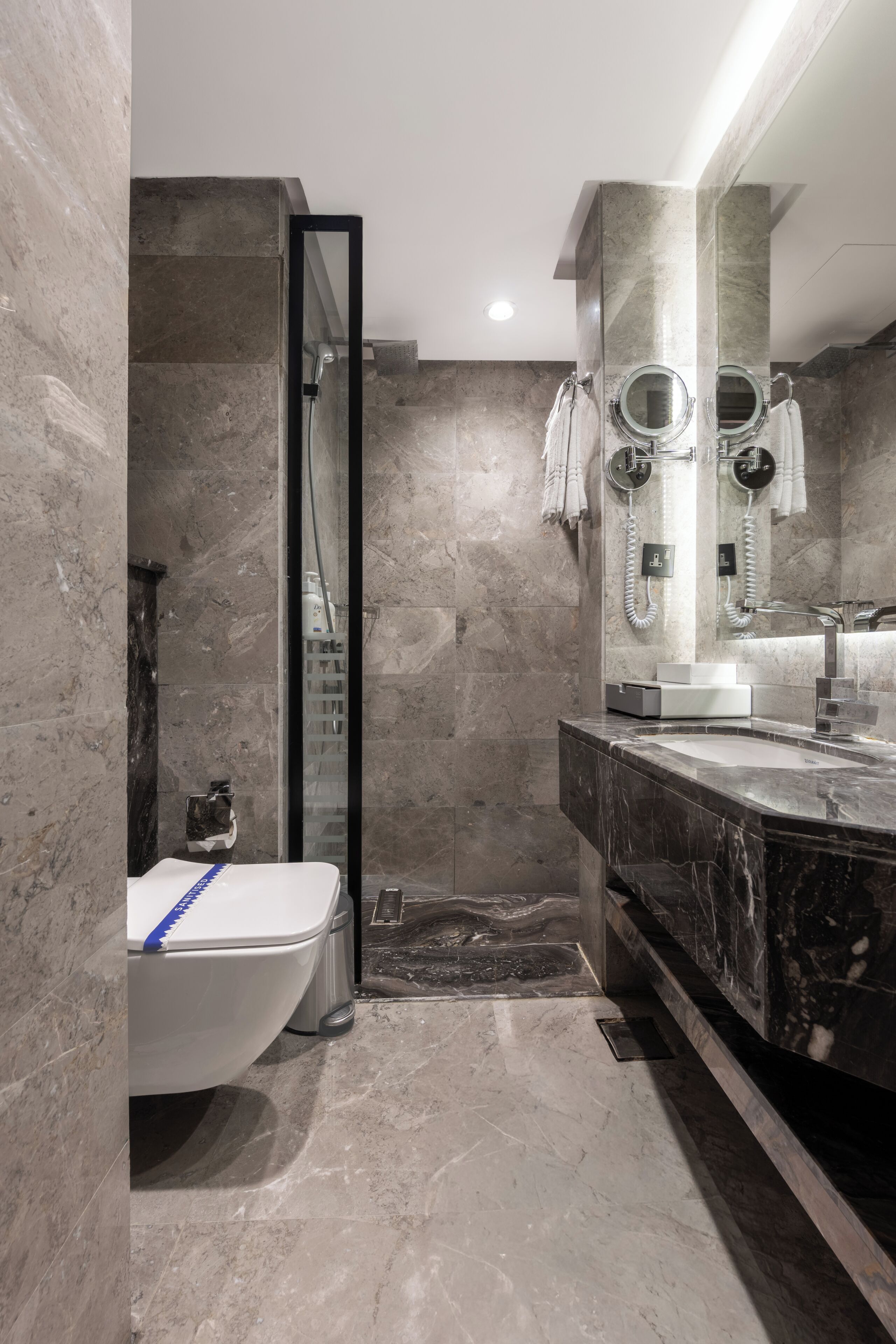 A modern bathroom with a freestanding bathtub, a walk-in shower, and a large mirror above the sink.