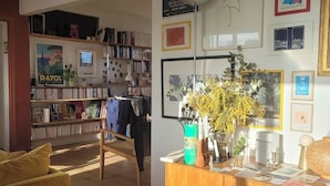 A cozy living room with a wooden coffee table, a yellow sofa, and a bookshelf filled with books and decorative items. - Buttes Chaumont top floor loft: unobstructed view of Paris! (Paris)
