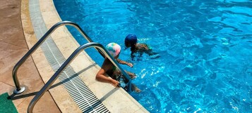 Una piscina cubierta, una piscina al aire libre, tumbonas