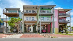 A multi-story building with balconies, a covered entrance, and a parking area. - Steps to Beach: Waterfront Cedar Key Home! (Cedar Key)