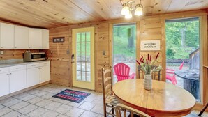 A wooden cabin interior with a kitchen, dining area, and a sign welcoming visitors to the ranch. - Mountain-view Cabin on Farm: 3 Mi to Town & Shops (Mountain View)