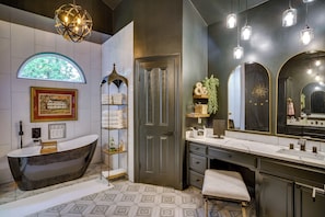A modern bathroom with a freestanding bathtub, a vanity with a large mirror, and a geometric patterned floor. - Elegant Baton Rouge Home w/ Yard ~ 3 Mi to Lsu! (Baton Rouge)