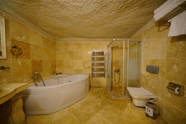 A bathroom with a bathtub, toilet, and shower. - vezir cave suites (Nevsehir)