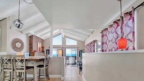 Una cocina amplia con comedor, una pared de detalles de ladrillo y vistas al exterior.