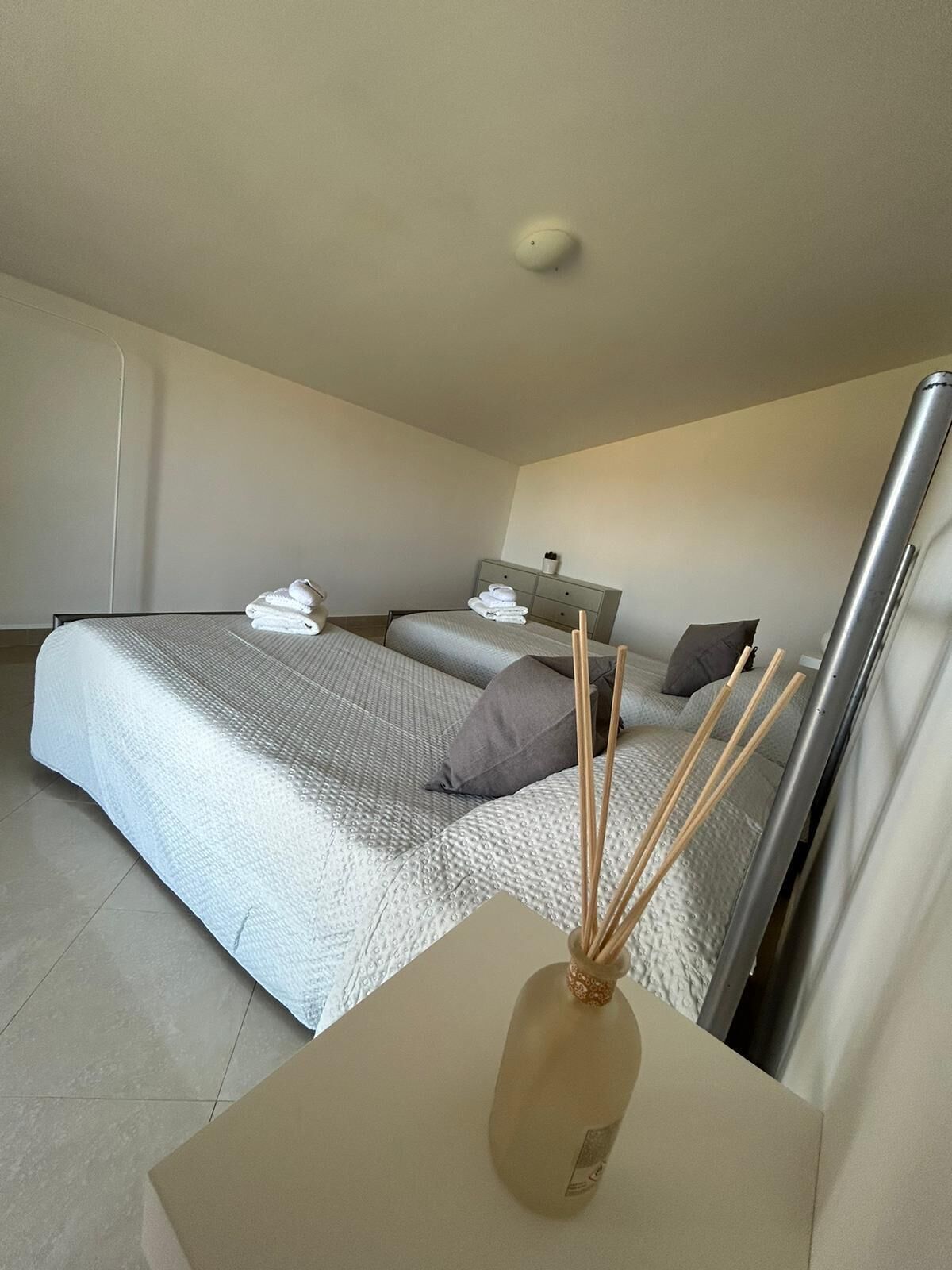A modern bedroom with a bed, a bedside table, and a nightstand.