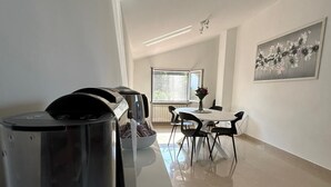 Eine moderne Küche mit einer langen Arbeitsplatte, einer Kaffeemaschine und einer Fruchtschüssel.