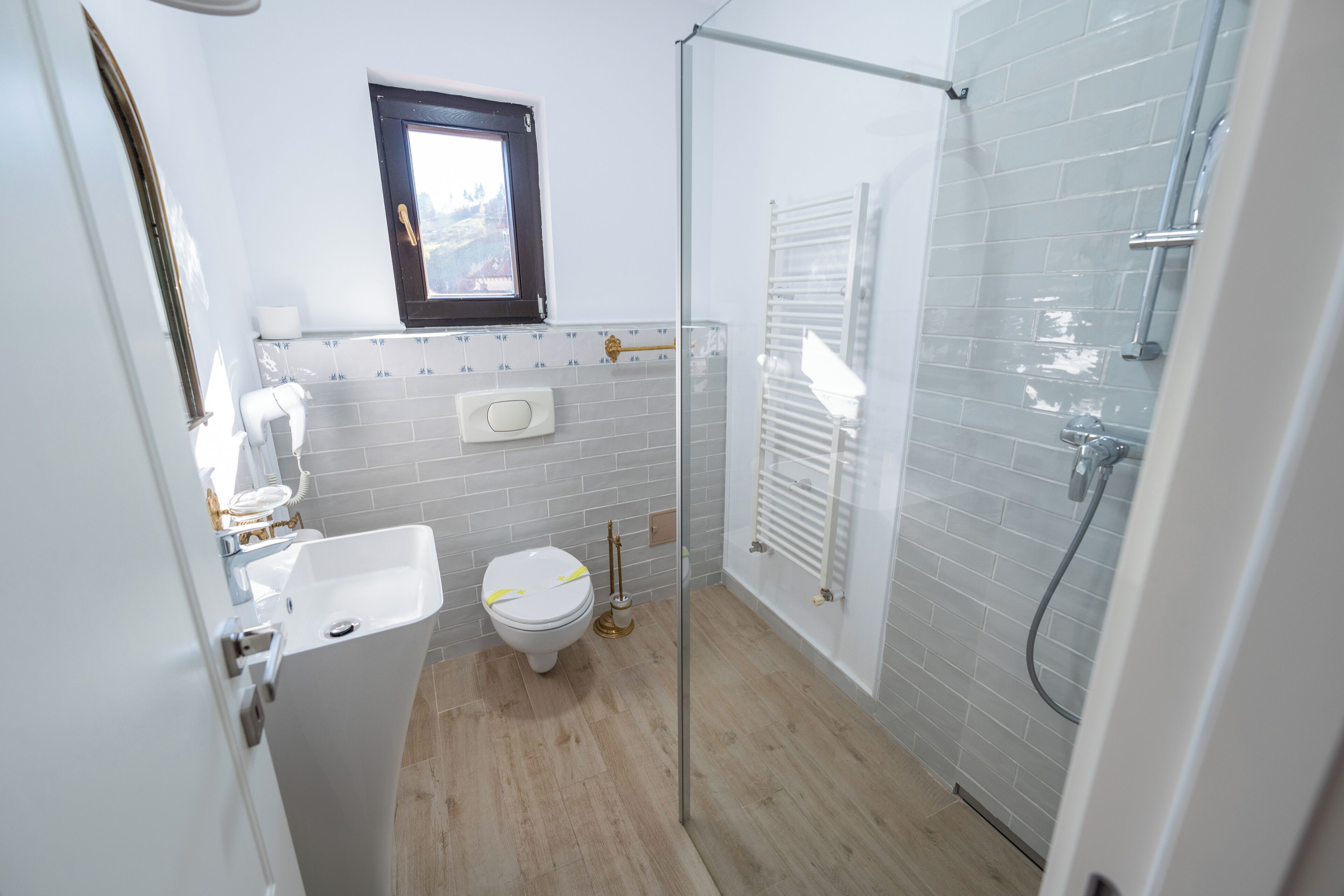 Une salle de bain moderne équipée de toilettes, d’un lavabo et d’une douche à parois de verre.