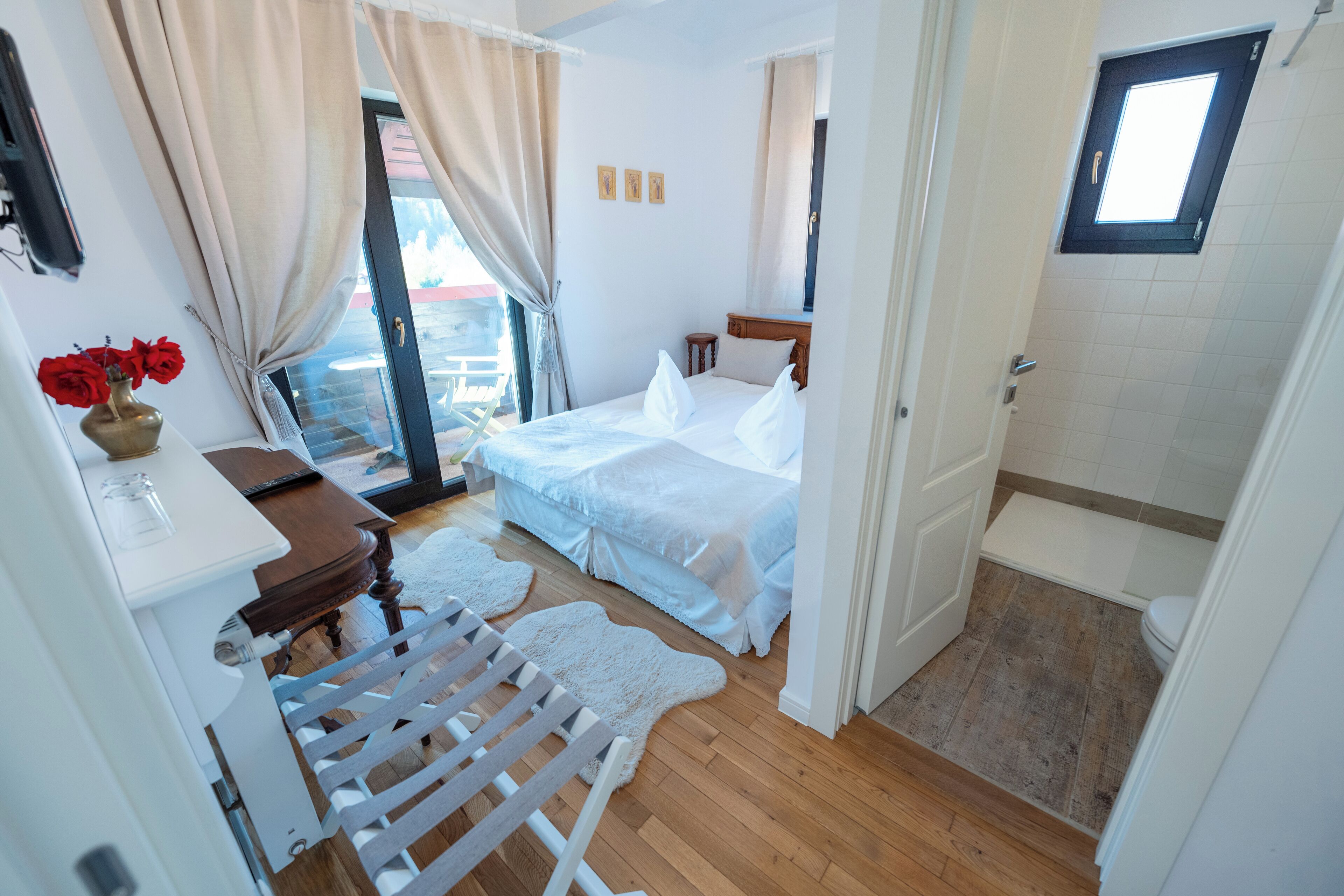 Un dormitorio con cama, escritorio, silla y ventana.