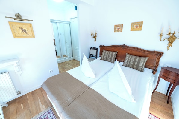 Un dormitorio con una cama grande, un cabecero de madera y una mesita de noche con una lámpara.
