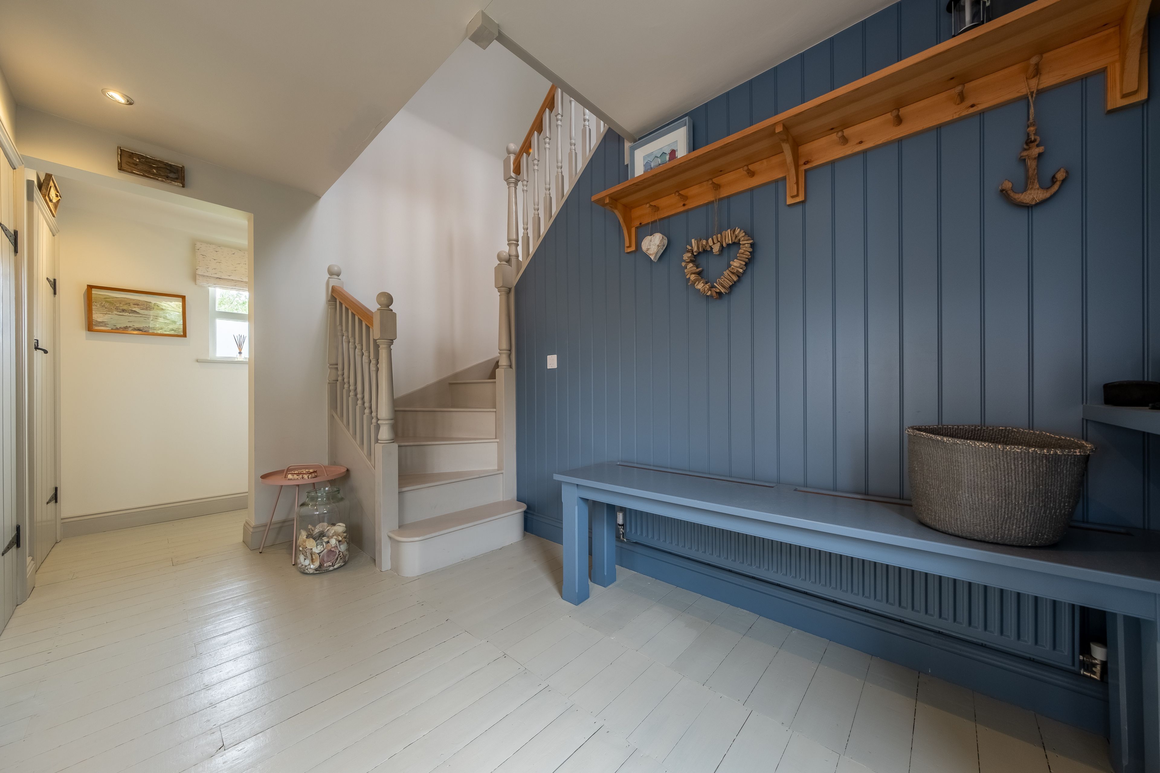 Eine Treppe führt zu einer zweiten Etage, eine Bank mit einem Korb und eine Wand mit herzförmlicher Dekoration.