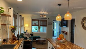 Une cuisine moderne avec des plans de travail en bois, un îlot central et des luminaires suspendus.