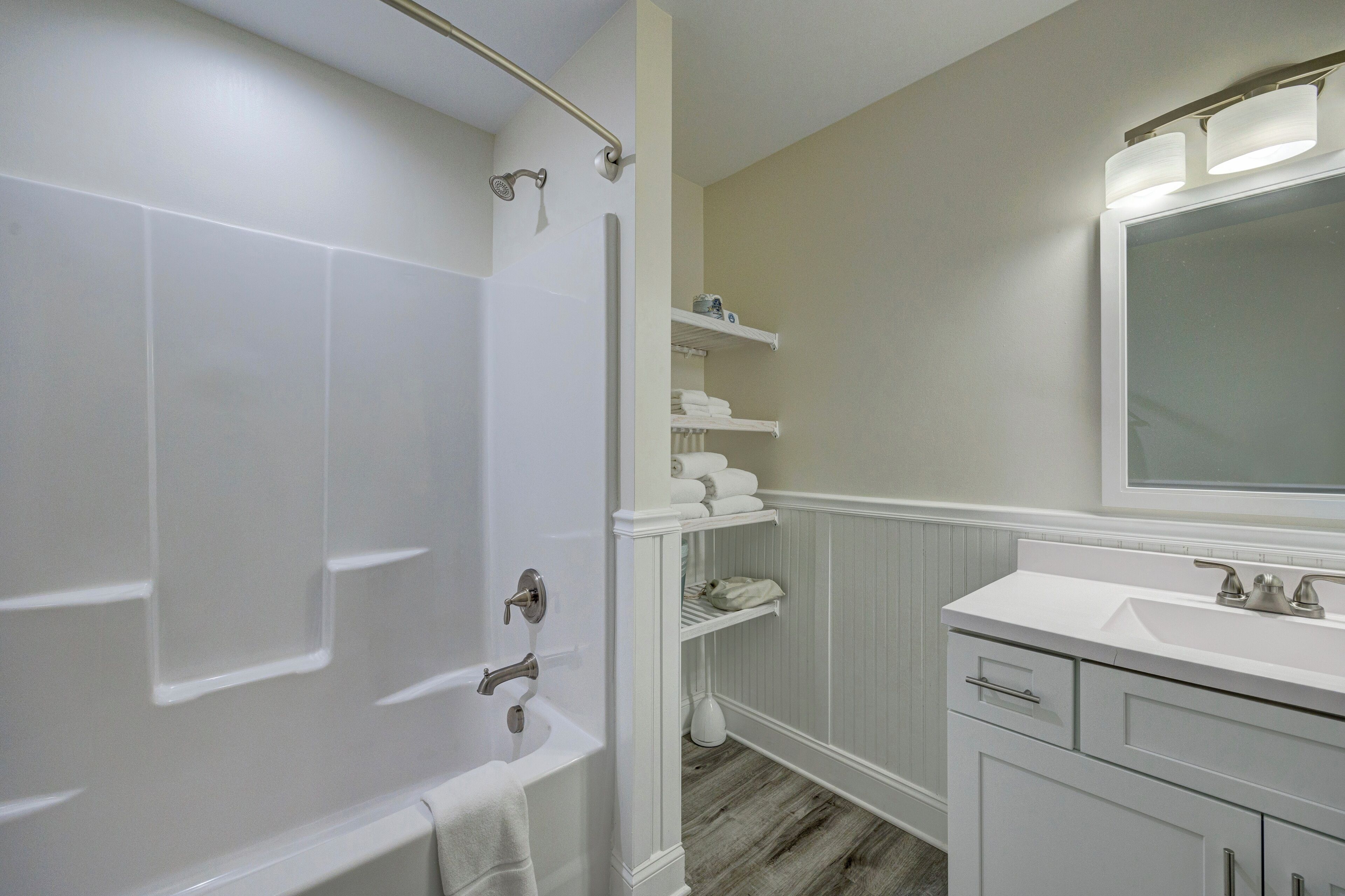 Un baño con bañera, lavamanos y espejo.