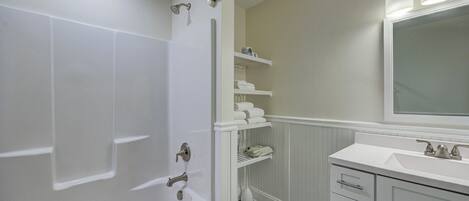 Un baño con bañera, lavamanos y espejo.